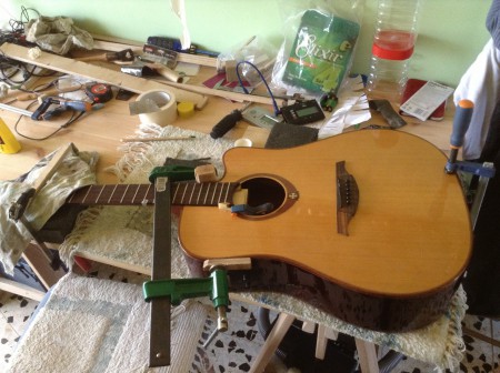 Encolado de tapa al mástil en la parte superior, con refuerzo provisional en el interior.